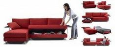 a woman standing next to a red couch with its storage compartment open in front of it