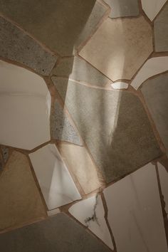 the floor is made up of many different colors and shapes, including grays, beiges, and browns