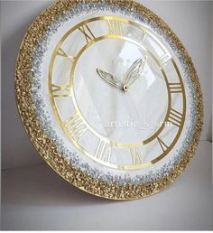 a gold and white clock with roman numerals on it's face is shown