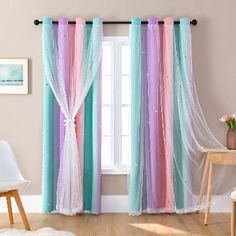 the curtains are hanging in front of the window with white drapes and pink, blue, and green colors