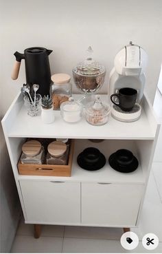 a coffee maker and other kitchen items on a white shelf