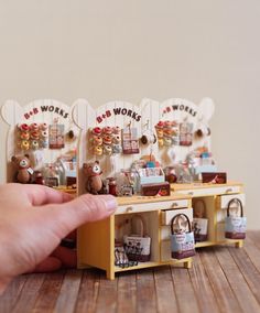 a hand is pointing at the wooden shelves with teddy bears on them