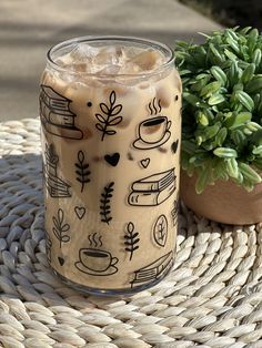 a drink sitting on top of a wicker table next to a potted plant