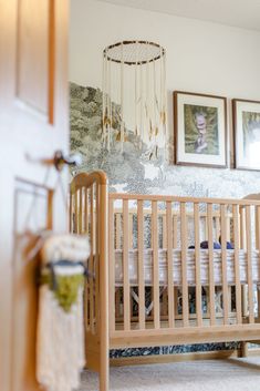 a baby's crib in a room with pictures on the wall