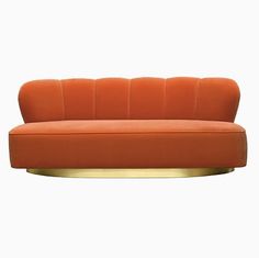 an orange couch sitting on top of a metal stand