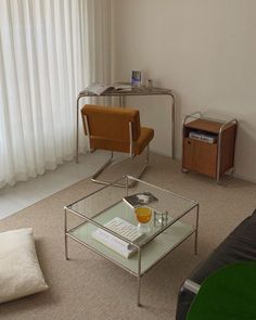 a living room with a couch, coffee table and chair in front of a window