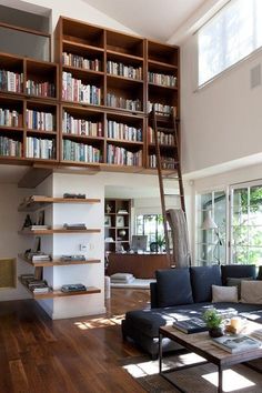 a living room filled with lots of furniture and bookshelves