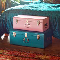 three suitcases stacked on top of each other in front of a bed