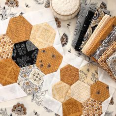 a table topped with lots of different types of quilts and papers on top of each other