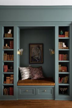 a bookshelf filled with lots of books next to a painting on the wall