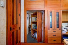 an open book shelf in the corner of a room next to a chair and desk