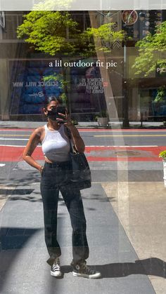 a woman taking a selfie in front of a store window