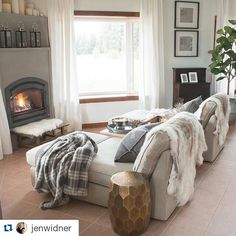 a living room filled with furniture and a fire place next to a window in front of a fireplace