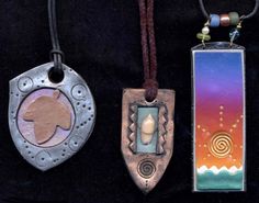 three pendants with different designs on them