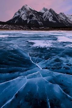 an ice floet with mountains in the background at sunset or sunrise, as seen from across the frozen water