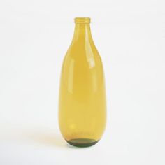 a yellow glass bottle sitting on top of a white table