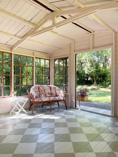 a room with large windows and a checkered floor