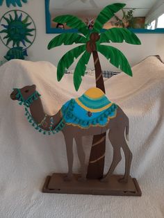 a paper cutout of a camel under a palm tree