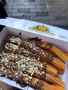 a box filled with lots of different types of food on top of a table next to a sidewalk