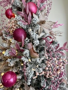 a decorated christmas tree with pink and silver ornaments