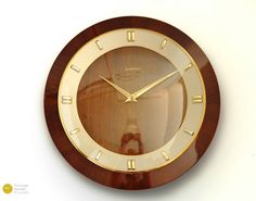 a wooden clock with roman numerals on the face is shown against a white background