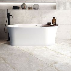 a white bath tub sitting on top of a tiled floor