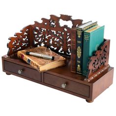 a wooden book holder with two books and a pen on top of it next to a pair of drawers