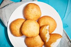 a white plate topped with muffins on top of a blue cloth covered table