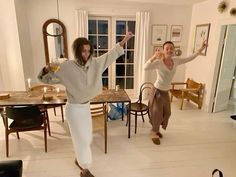 two people are dancing in the living room