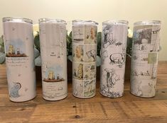 the winnie the pooh tumblers are lined up against each other on a wooden table