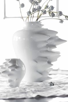 a white vase with some flowers in it