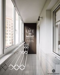 a white bench sitting next to a window in a room filled with lots of windows