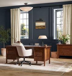 an office with blue walls and wooden furniture in the center, along with a rug on the floor