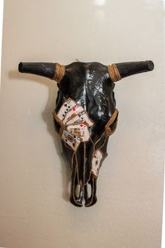 a bull's head is adorned with playing cards and bulls horns are hanging on the wall