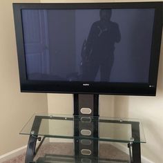 a flat screen tv sitting on top of a glass table