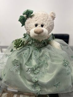 a teddy bear dressed in a green dress