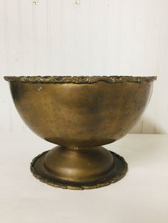 a large metal bowl sitting on top of a white table