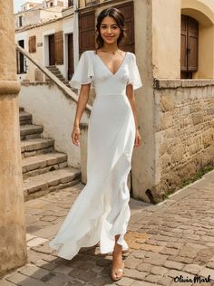 a woman in a white dress is walking down the street