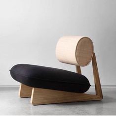 a black and white pillow sitting on top of a wooden stand next to a wall