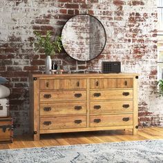 a bedroom with a brick wall and wooden dresser in front of a mirror on the wall