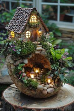 a small house made out of logs with lights in the windows and plants growing inside