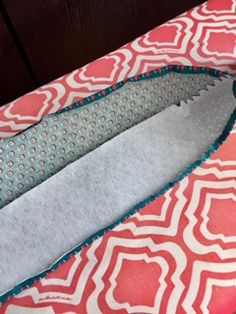 the inside of a pink and white bed with an ironing board on top of it