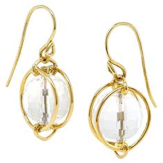 A lustrous crystal is paired with the radiance of 18k yellow gold for these drop earrings. A globe of crystal is double-faceted to play off the light. The gold wire within the crystal holds it in place, while a pair of gold hoops secured to a triangular-shaped loop at the top and bottom protect the crystal. Joined above the upper triangular loop is a French hook. The total weight is 2 carats of quartz. Measurements for the earrings are 0.47 inches (width) by 0.83 inches (length) by 0.47 inches ( Small Lanterns, A Globe, Bracelet Love, French Wire, Gold Wire, Modern Earrings, Wire Earrings, Gold Drop Earrings, Love Ring