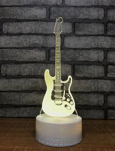 an electric guitar shaped lamp on top of a table