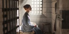 a woman sitting on top of a window sill