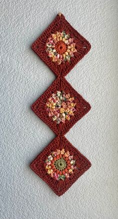 three crocheted squares hanging on the wall