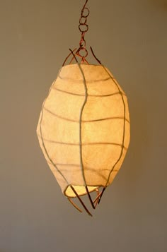 a light hanging from a ceiling in the shape of a ball with wires attached to it