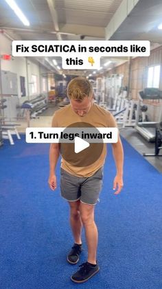 a man standing on top of a blue carpet in a gym