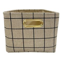 a beige basket with black and white checkered fabric, gold handles and metal handle