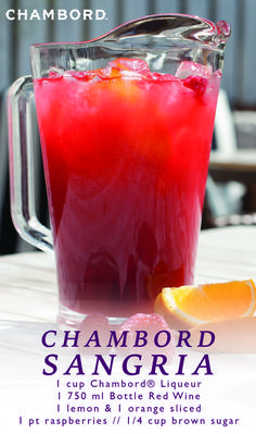 a glass pitcher filled with liquid next to an orange slice